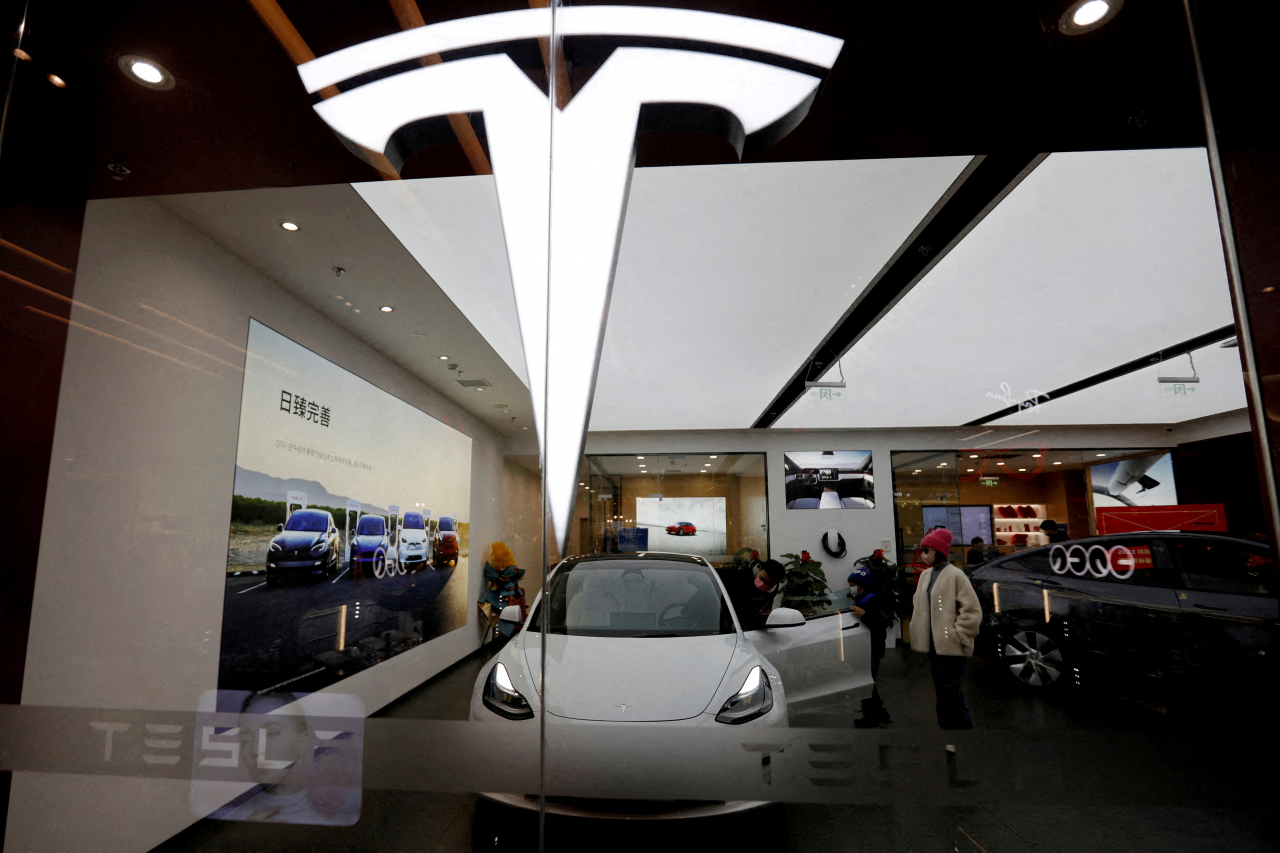 Visitors check a Tesla Model 3 car next to a Model Y displayed at a showroom of the US electric vehicle maker in Beijing, China Feb. 4. (Reuters)