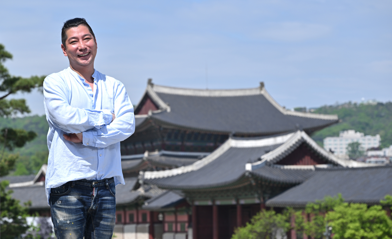 Song Jae-sung, the director overseeing Gyeongbokgung shows during the K-Royal Culture Festival this week, poses for a photo with the palace in the background on April 22. (Im Se-jun/The Korea Herald)