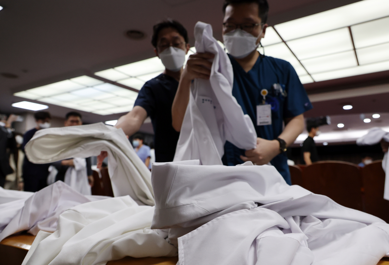 Medical professors at Wonkwang University Hospital in Iksan, North Jeolla Province, take off their white coats after submitting their resignations on Monday. (Yonhap)
