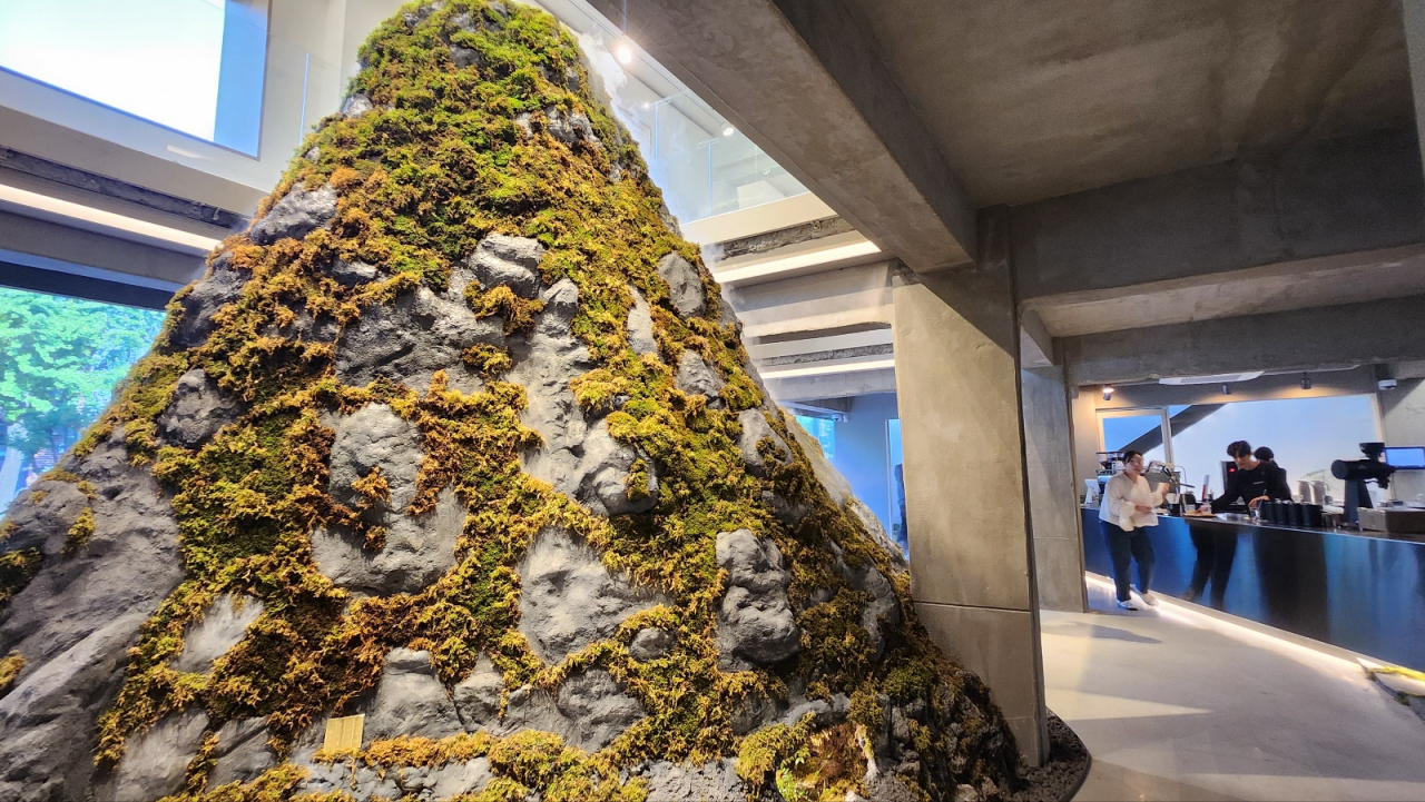 A mountain-shaped sculpture decorated with moss and a small waterfall stands in the center of Leedorim, Jongno-gu, Seoul. (Lee Jung-youn/The Korea Herald)