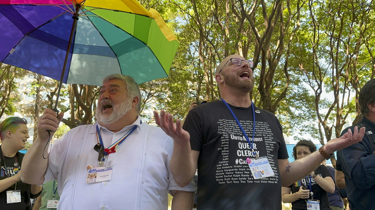 The Rev. David Meredith (left) and the Rev. Austin Adkinson sing during a gathering of LGBTQ+ people and allies outside the Charlotte Convention Center in Charlotte, North Carolina, on May 2. (AP-Yonhap)