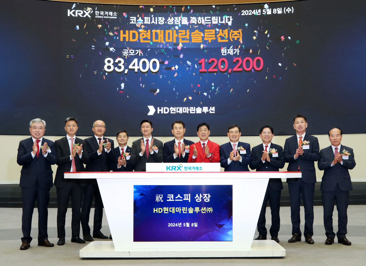 HD Hyundai Vice Chairman and CEO Chung Ki-sun (fifth from left), Korea Exchange CEO Jeong Eun-bo (sixth from left), HD Hyundai Marine Solution CEO Lee Ki-dong (seventh from left) and other company officials attend the listing ceremony of HD Hyundai Marine Solution in Seoul, Wednesday. (HD Hyundai)