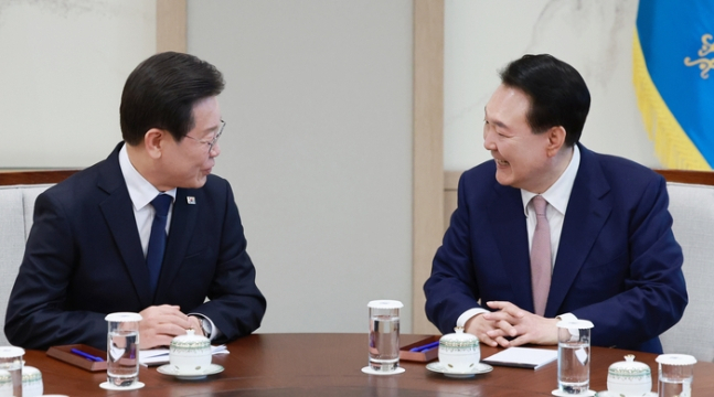 President Yoon Suk Yeol (right) speaks with opposition leader Lee Jae-myung at a meeting held on April 29. (Yonhap)