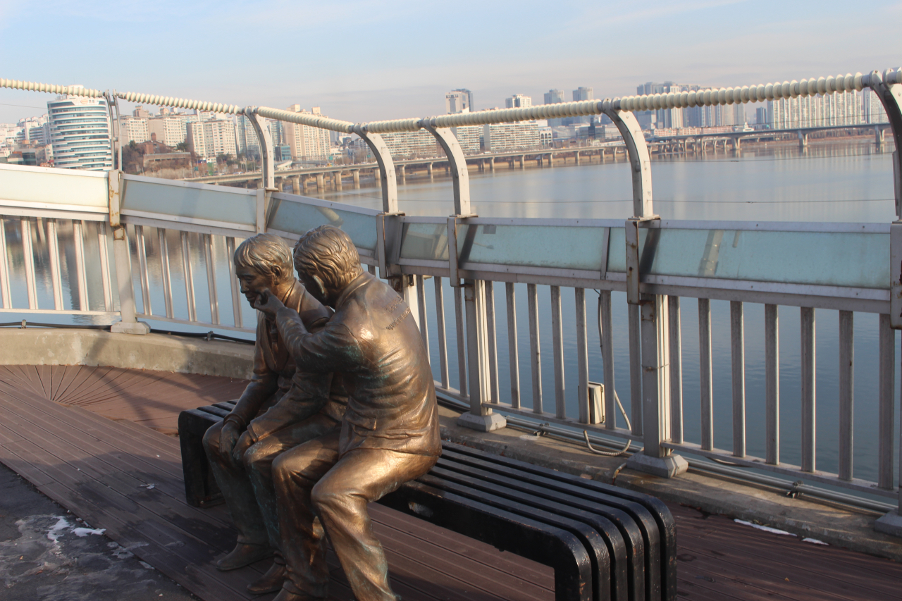 A statue a man comforting a friend is seen placed in the middle of the Mapo Bridge over the Han River in Seoul. (Yoon Min-sik/The Korea Herald)