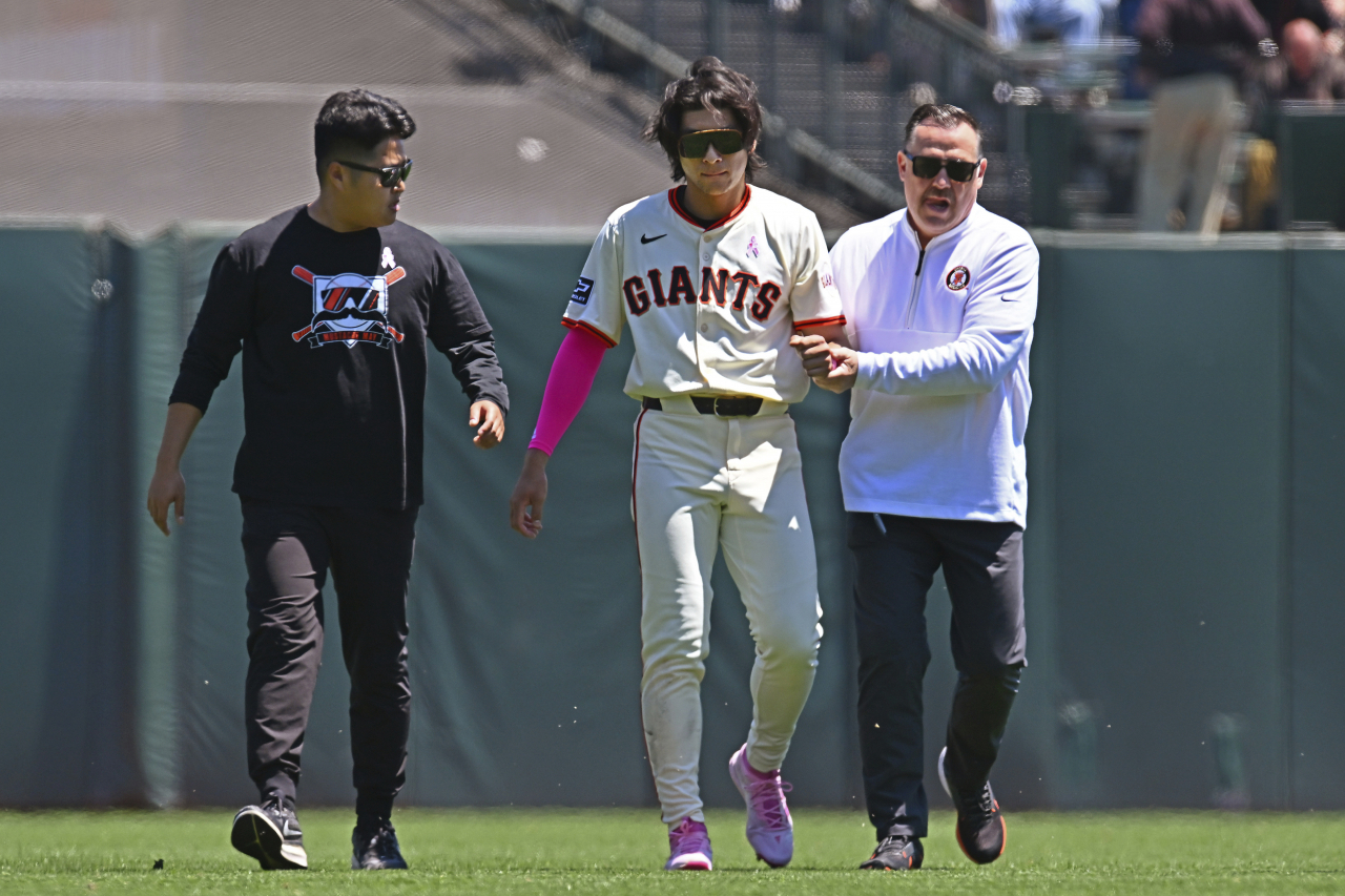 San Francisco Giants' Lee Jung-hoo(Center) is escorted to the locker room by a trainer and his translator after an injury in the first inning of a game against the Cincinnati Reds in San Francisco, Sunday. (AP)