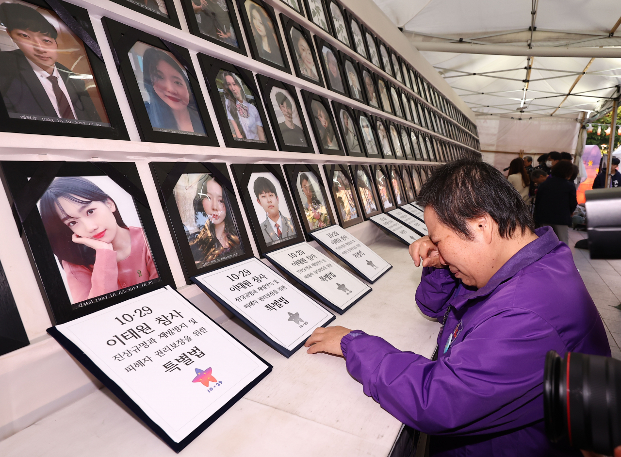 A bereaved family member of a victim of the 2022 Itaewon tragedy sheds tears in front of the memorial installed next to the Seoul City Hall on May 2, 2024. The National Assembly passed a special bill mandating an in-depth investigation into the tragedy on the same day. (Yonhap)