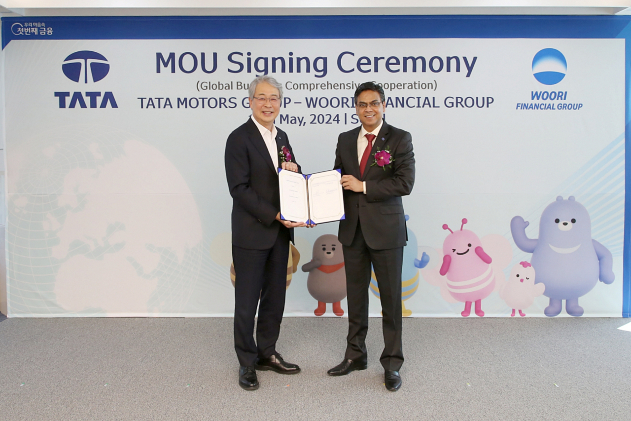 Woori Financial Group Chairman Yim Jong-yong (left) and Tata Motors Executive Director Girish Wagh pose for a photo during a partnership signing ceremony held at Woori's headquarters in Seoul on Thursday. (Woori Financial Group)