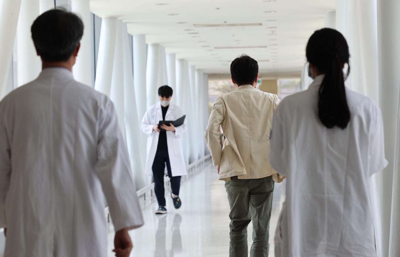 Medical personnel walk in a hallway at a university hospital in Seoul on Friday. (Yonhap)
