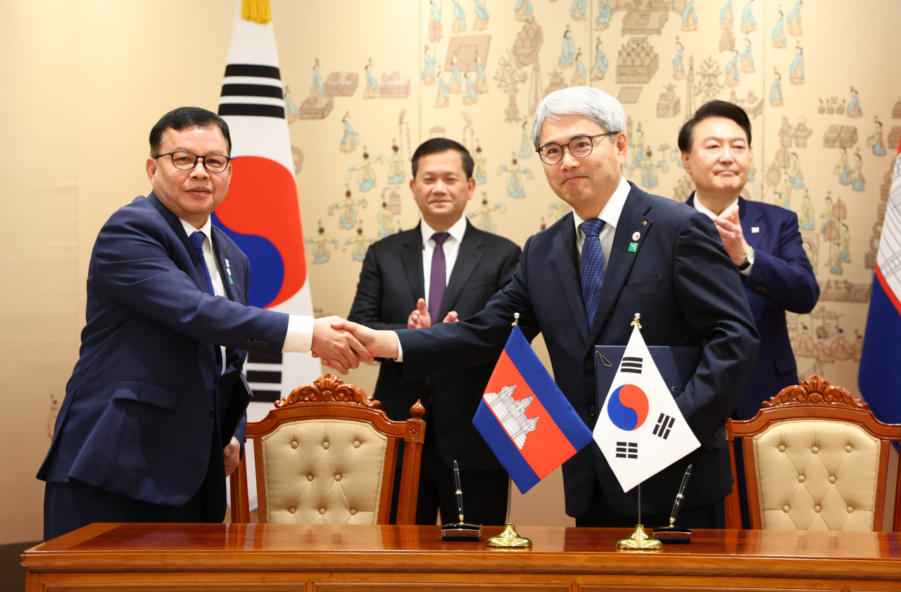 Korea Export-Import Bank President Yoon Hee-sung (second from right) and Cambodia's Secretary of State at the Ministry of Economy and Finance ROS Seilava (left) shake hands during a signing ceremony held Thursday at the presidential office in Seoul, with South Korean President Yoon Suk Yeol (right) and Cambodian Prime Minister Hun Manet in attendance. (Yonhap)