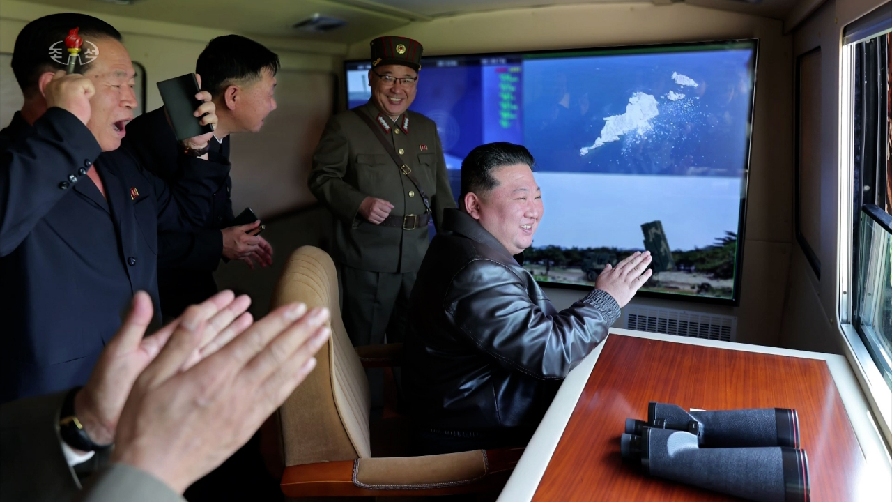 North Korean leader Kim Jong-un (right) oversees a test-firing of a tactical ballistic missile equipped with a new 