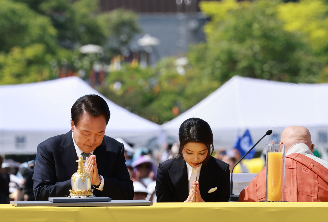President Yoon Suk Yeol (left) and first lady Kim Keon Hee (second from left) bow at a ceremony to celebrate the return of the 14th-century Buddhist relics at Hoeamsa in Gyeonggi Province, on Sunday. (Yonhap)