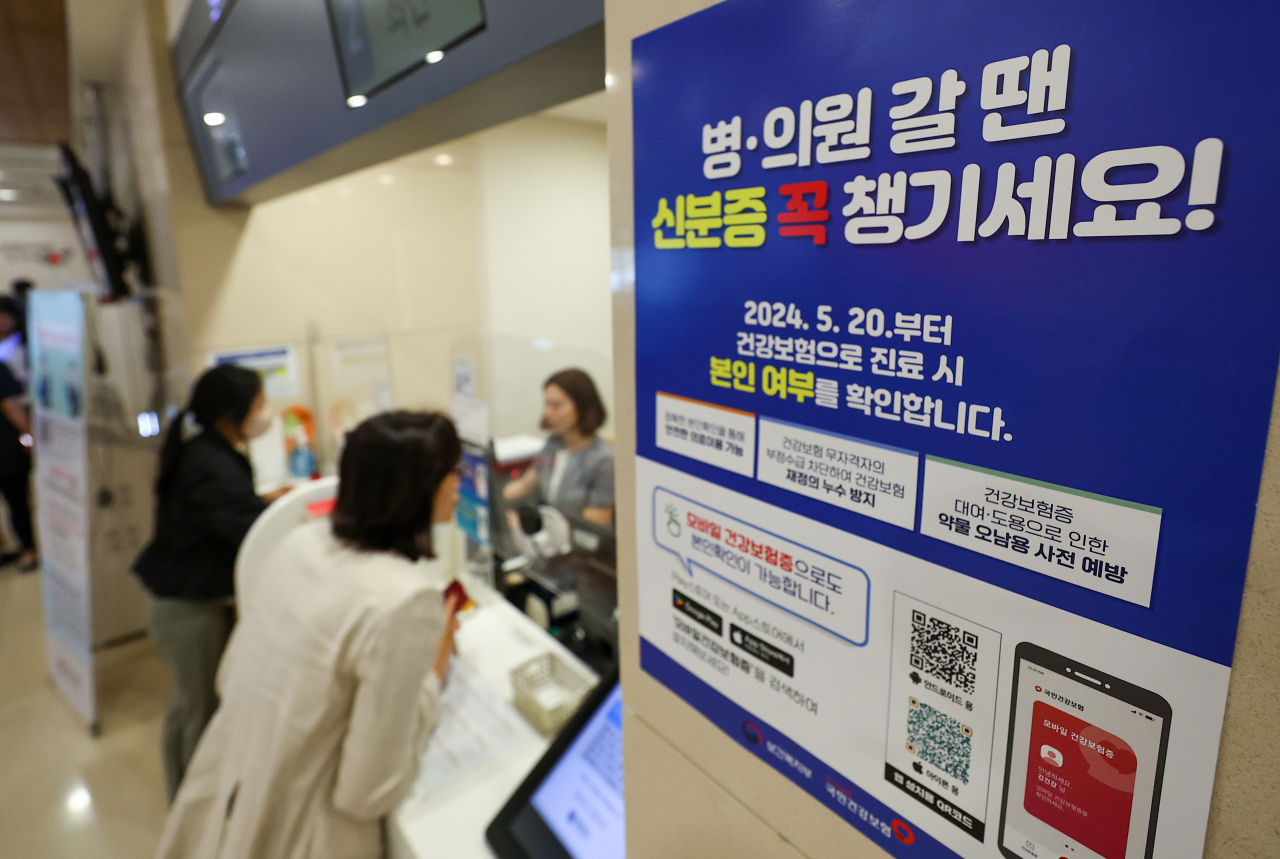 A notification at a Seoul hospital on Monday reminds visitors that one has to carry ID when receiving medical services, in order to receive state health insurance benefits. (Yonhap)