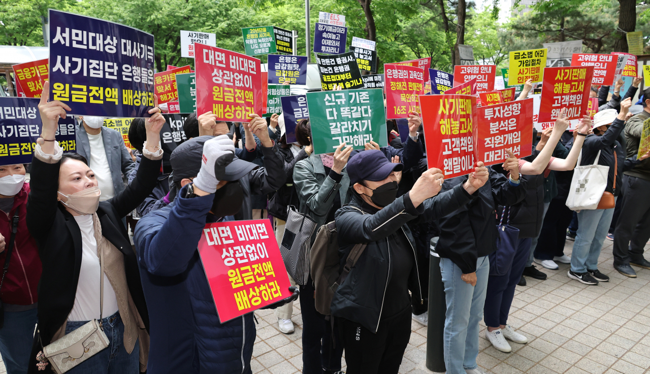 A group of retail investor who suffered losses from investment in equity-linked securities tracking Hong Kong's Hang Seng China Enterprises Index stage a protest in front of the Financial Supervisory Service building on April 24. (Yonhap)