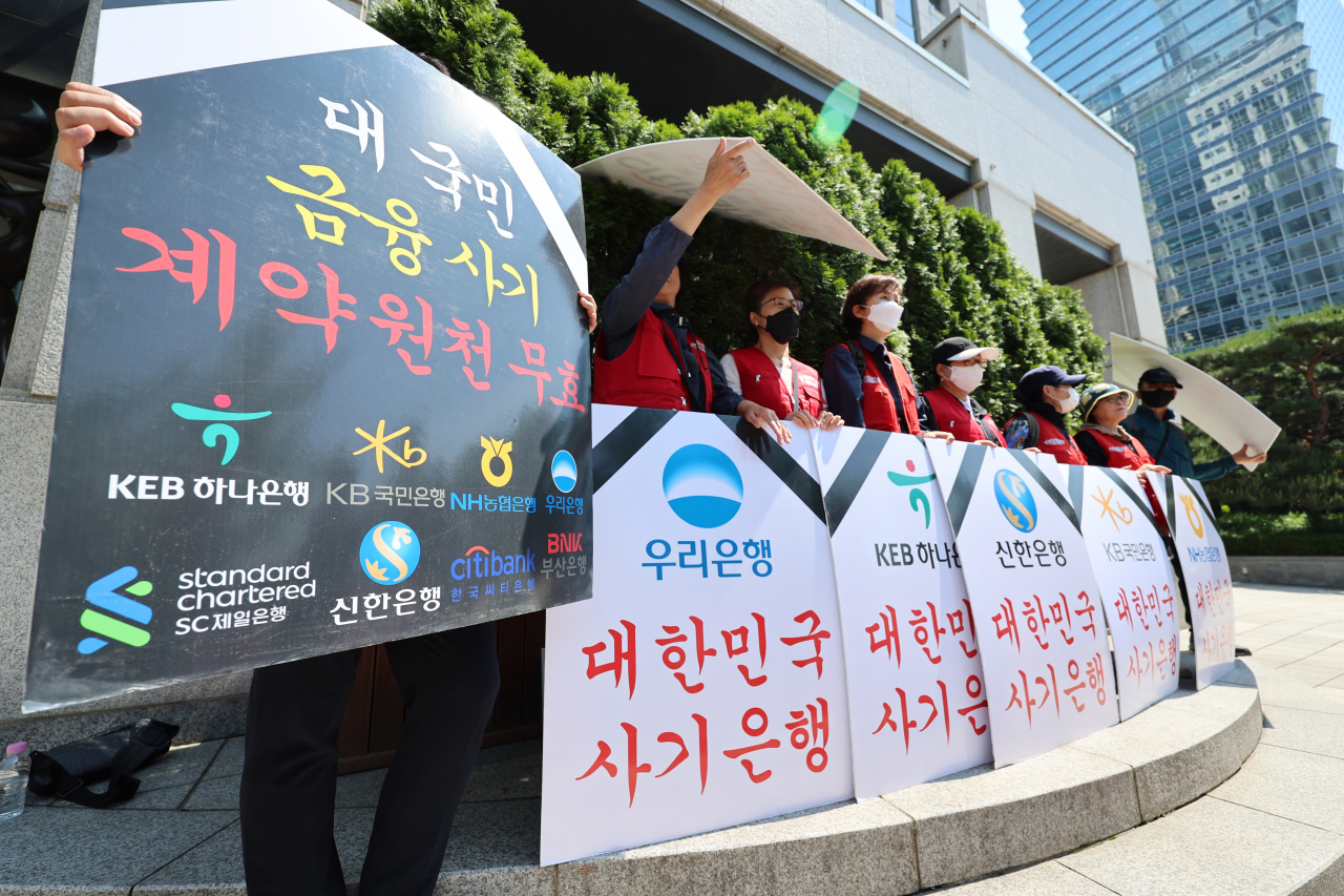 A group of investors who suffered losses from local banks' misselling of Hong Kong stock index-linked derivatives stage a protest in front of the Financial Supervisory Service headquarters in Yeouido, Seoul, on Tuesday. (Yonhap)