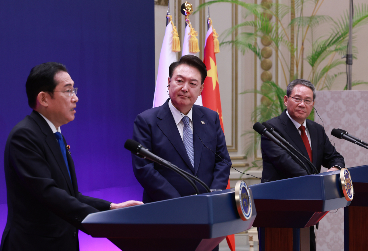 South Korean President Yoon Suk Yeol (center) and Chinese Premier Li Qiang (right) listen to Japanese Prime Minister Fumio Kishida speak during a joint news conference held at the guesthouse of the former presidential office, Cheong Wa Dae, in Seoul on Monday. (Yonhap)