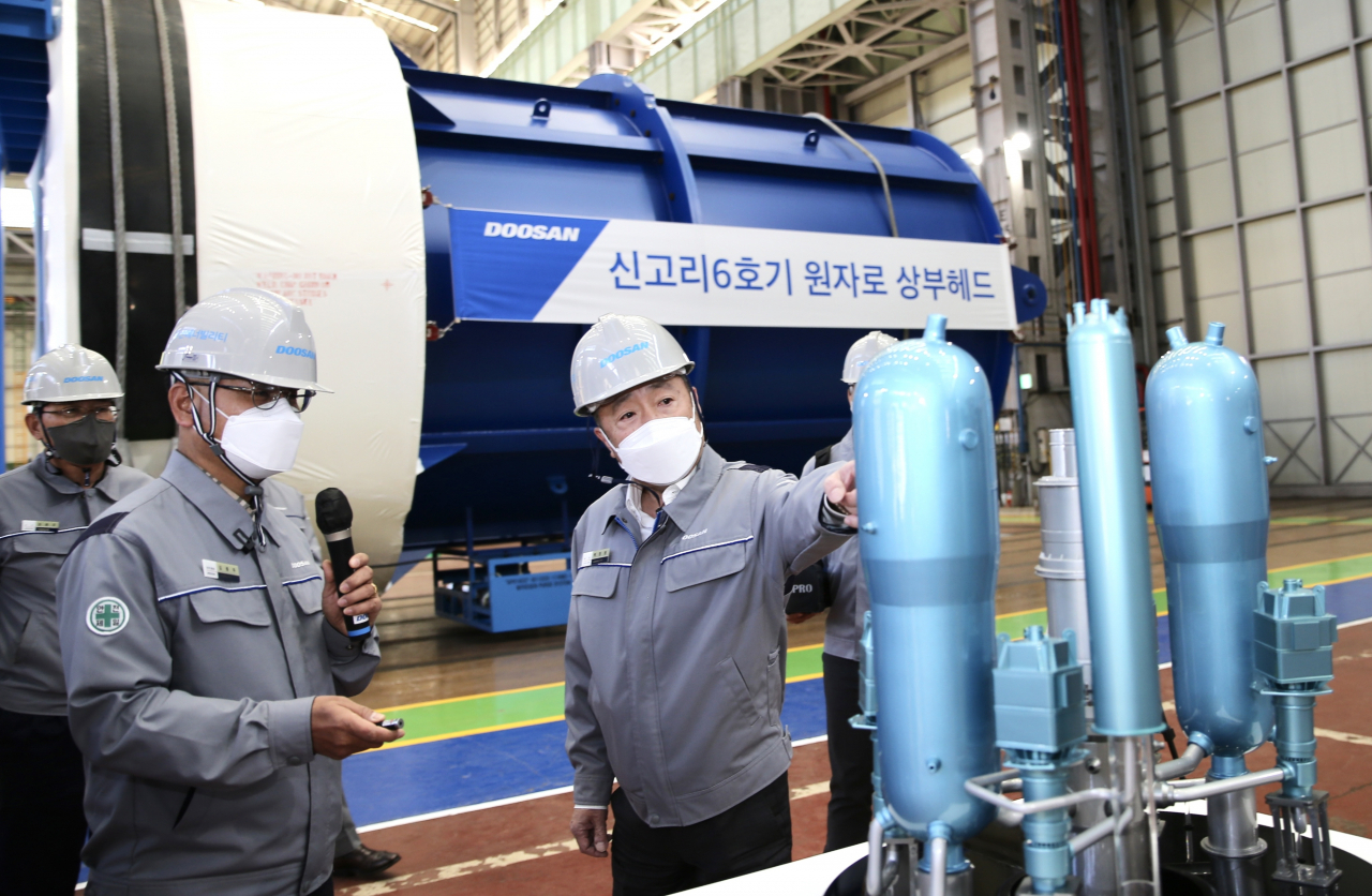 Doosan Group Chairman Park Jeong-won (center) examines reactor production at the Doosan Enerbility plant in Changwon, South Gyeongsang Province, during a walkthrough last November. (Doosan Group)