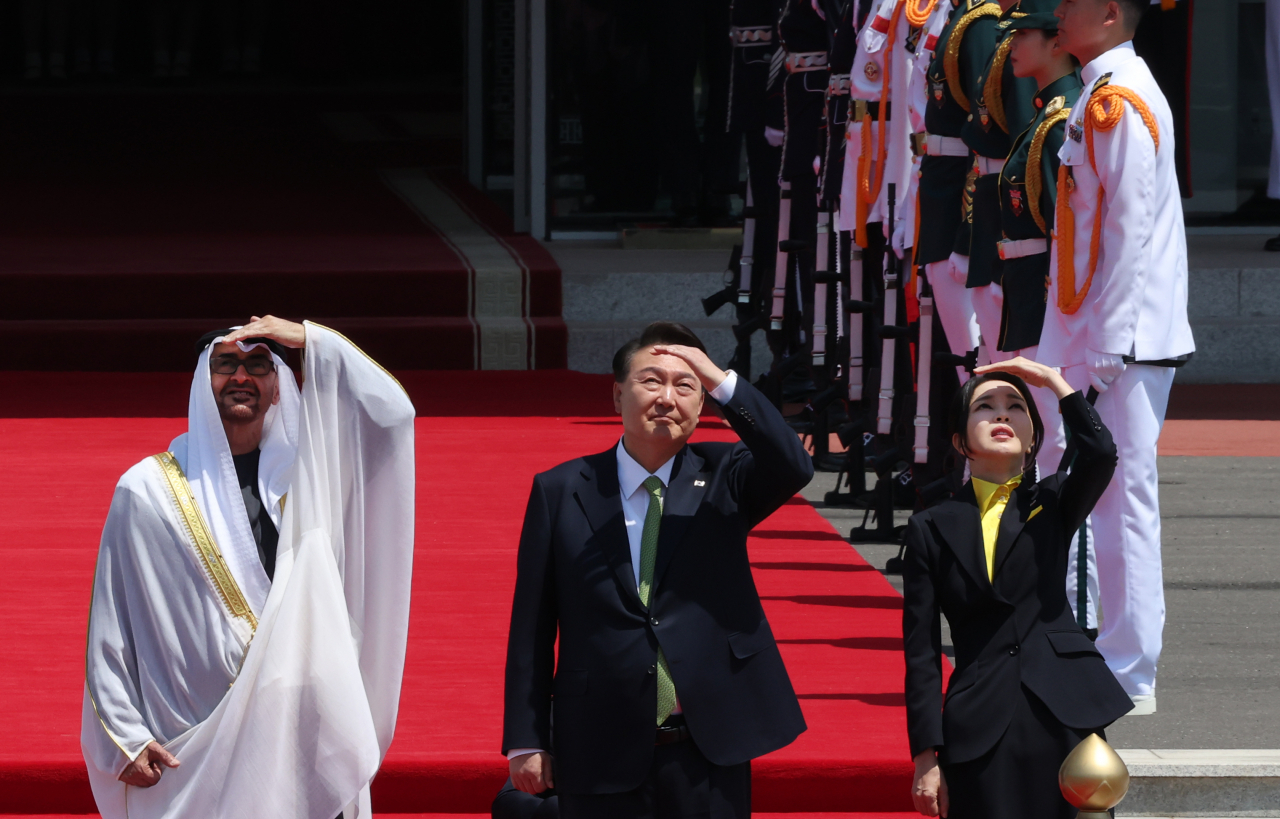 South Korean President Yoon Suk Yeol (center), his wife, Kim Keon Hee (right), and United Arab Emirates President Mohamed bin Zayed watch the flight of the Air Force's Black Eagles aerobatic team during a ceremony welcoming the UAE leader at the presidential office in Seoul on Wednesday. (Yonhap)