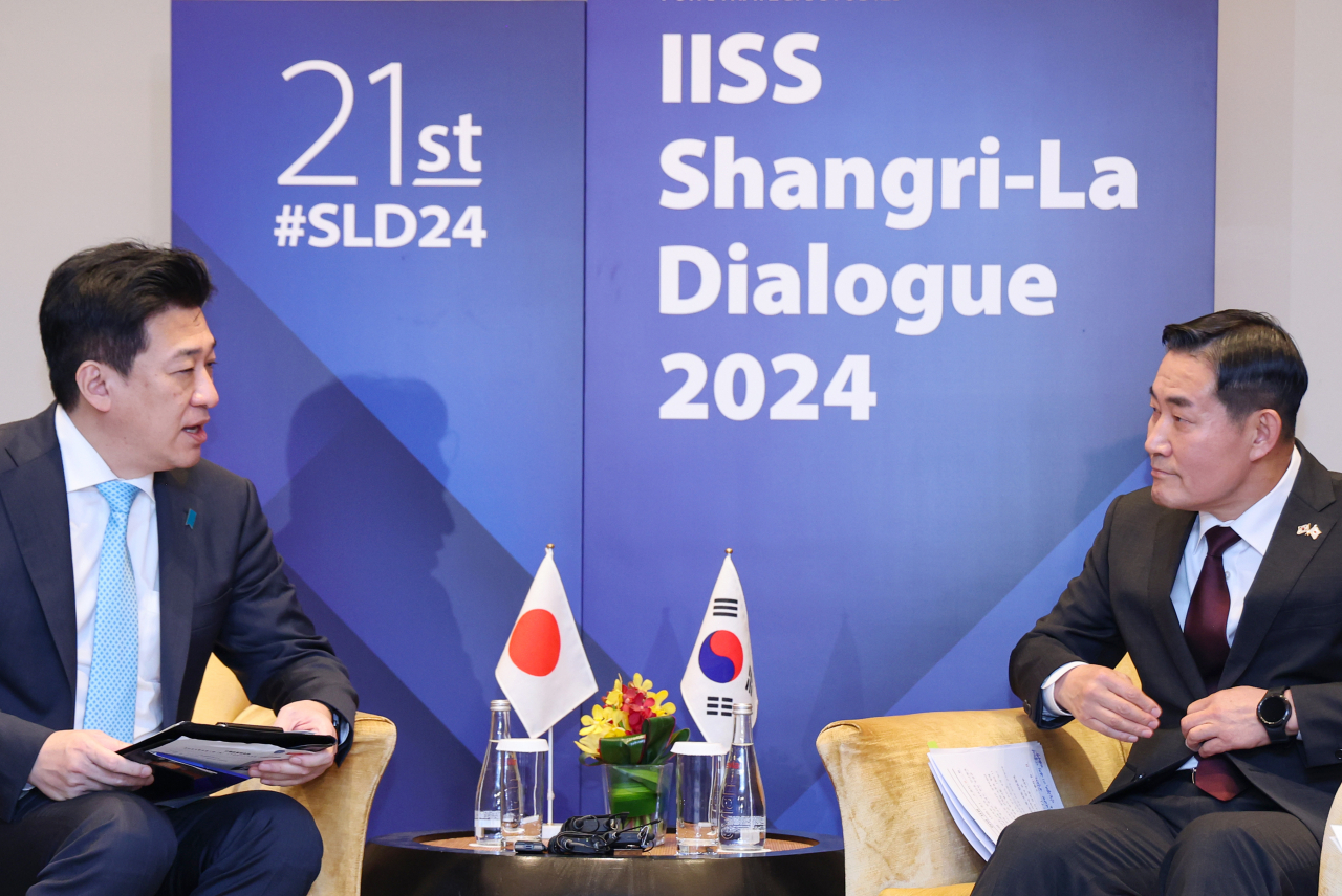 South Korean Minister of National Defense Shin Won-sik (right) and Japanese Minister of Defense Minoru Kihara hold a meeting at the Shangri-La Dialogue in Singapore on Saturday. (Yonhap)
