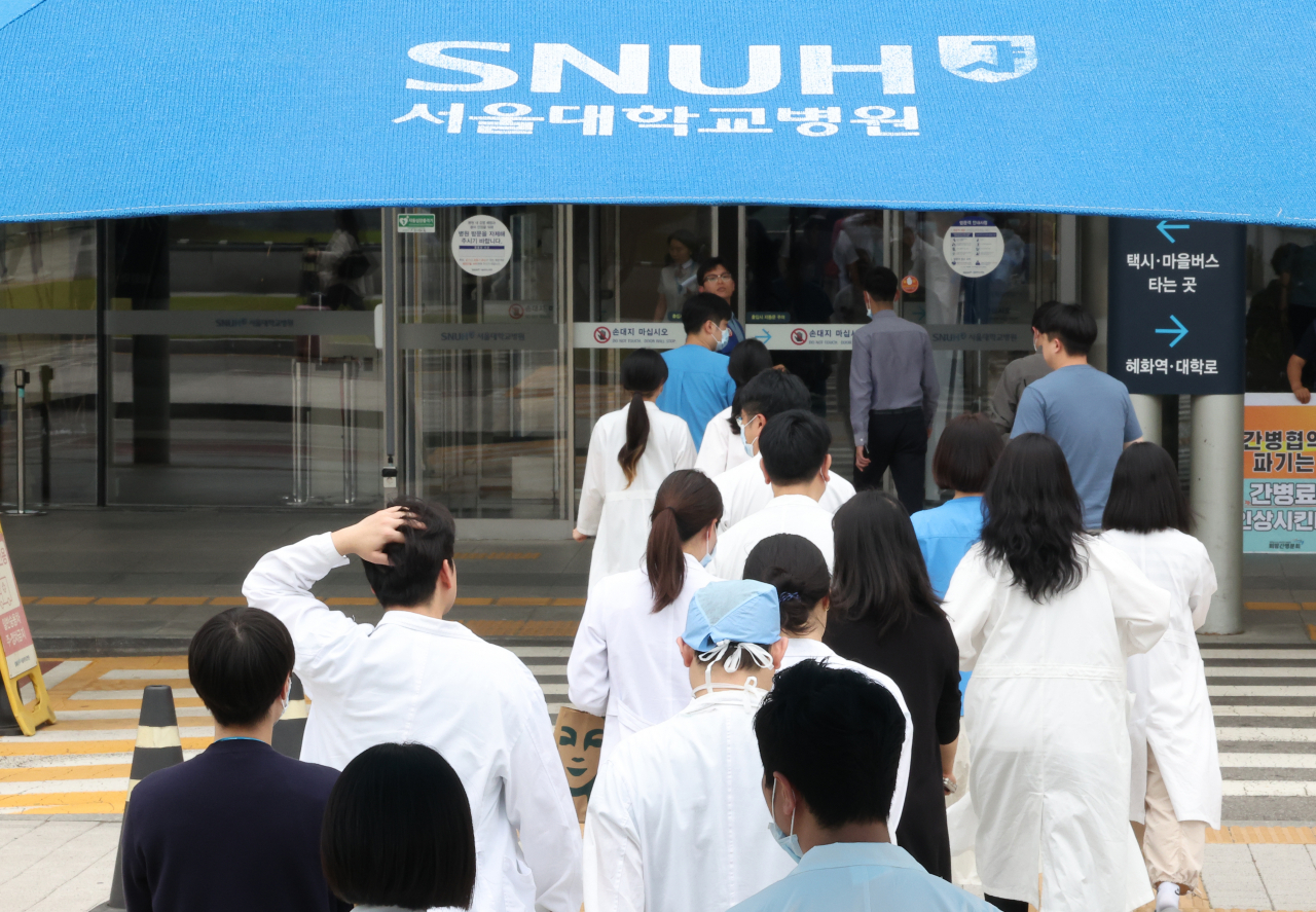 Doctors walk walks into a building of the Seoul National University Hospital in Seoul on Thursday. (Yonhap)