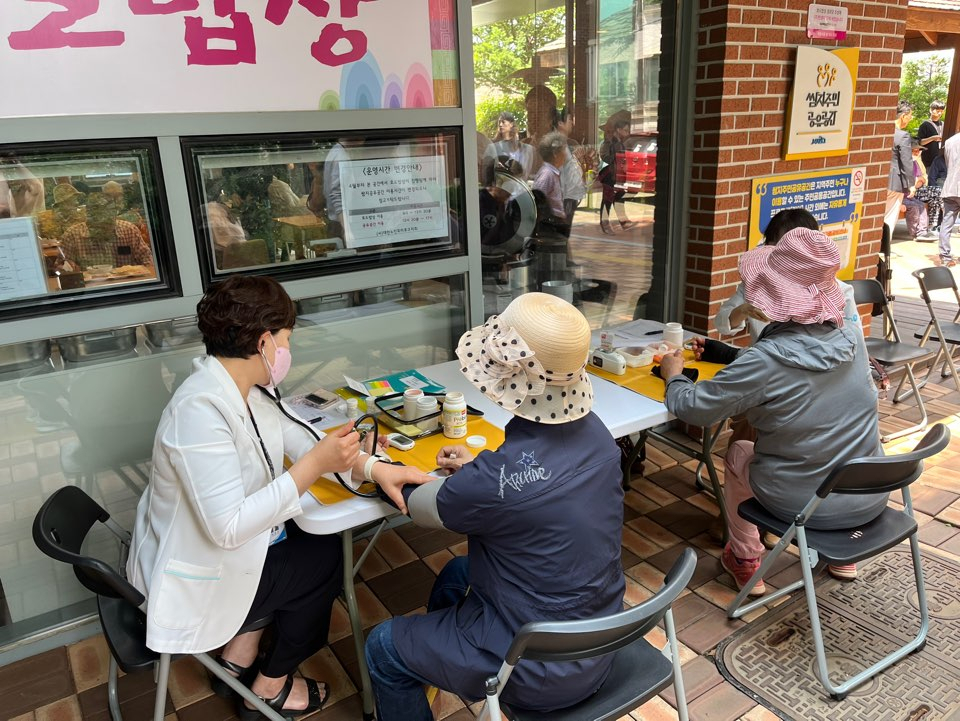 Participants of the Hyodo Babsang initiative have their blood pressure and blood sugar checked before receiving a meal, at a senior center in Mangwon-dong, Mapo-gu, Seoul, on May 21. (Lee Jaeeun/The Korea Herald)