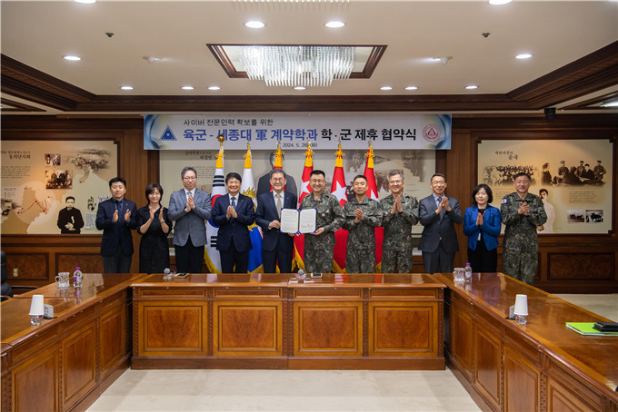 Sejong University President Bae Deok-hyo (fifth from the left), Army Chief of Staff Park Ahn-soo (sixth from the left) and other officials take a commemorative photo at an agreement ceremony between Sejong University and the Army on May 28, 2024. (Sejong University)