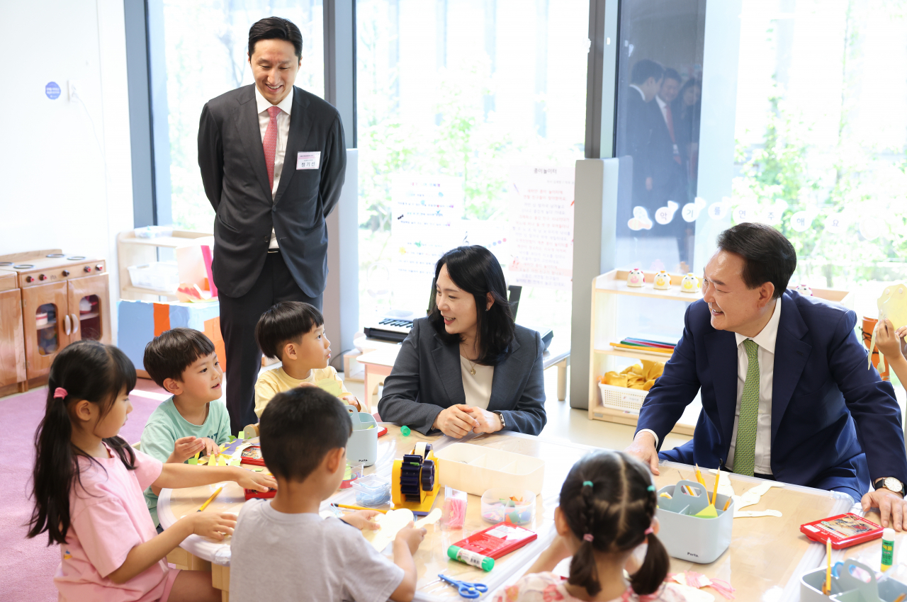 President Yoon Suk Yeol (right) observes children participating in a nursery program during his visit to HD Hyundai's daycare center, Dream Boat, located inside the HD Hyundai Global R&D Center in Bundang, Gyeonggi Province, Wednesday. (Pool photo via Yonhap)
