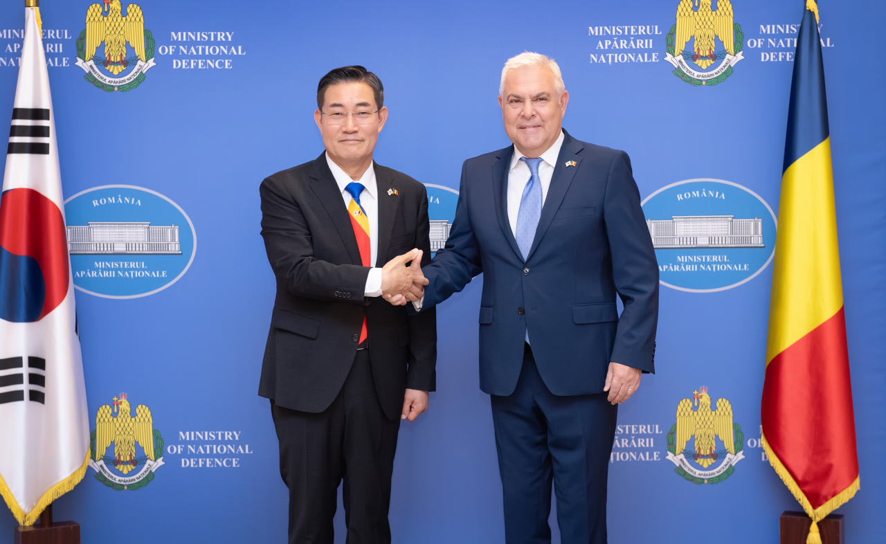 South Korean Defense Minister Shin Won-sik (left) and his Romanian counterpart, Angel Tilvar, shake hands during their meeting in Romania on Wednesday in this photo provided by Shin's office. (Yonhap)
