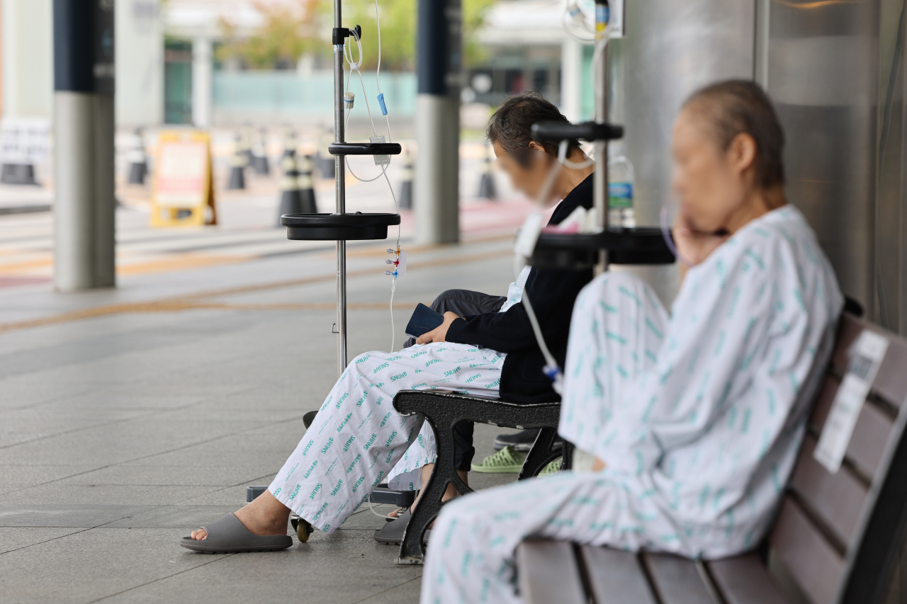 Patients take a break outside a general hospital in Seoul on Thursday. (Yonhap)