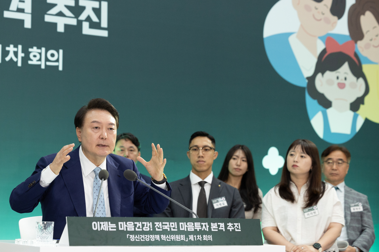 President Yoon Suk Yeol (left) speaks during a meeting of a presidential committee dedicated to expanding state support and changing the general perception toward mental illness in Seoul on Wednesday. (Yonhap)