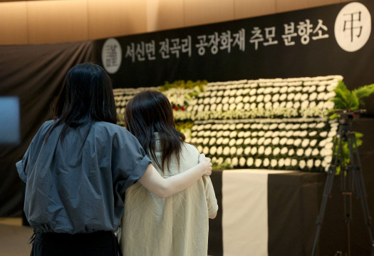 Bereaved family members comfort one another at a memorial for victims of Monday's Aricell lithium battery factory fire at Hwaseong City Hall in Hwaseong, Gyeonggi Province, Wednesday. (Yonhap)