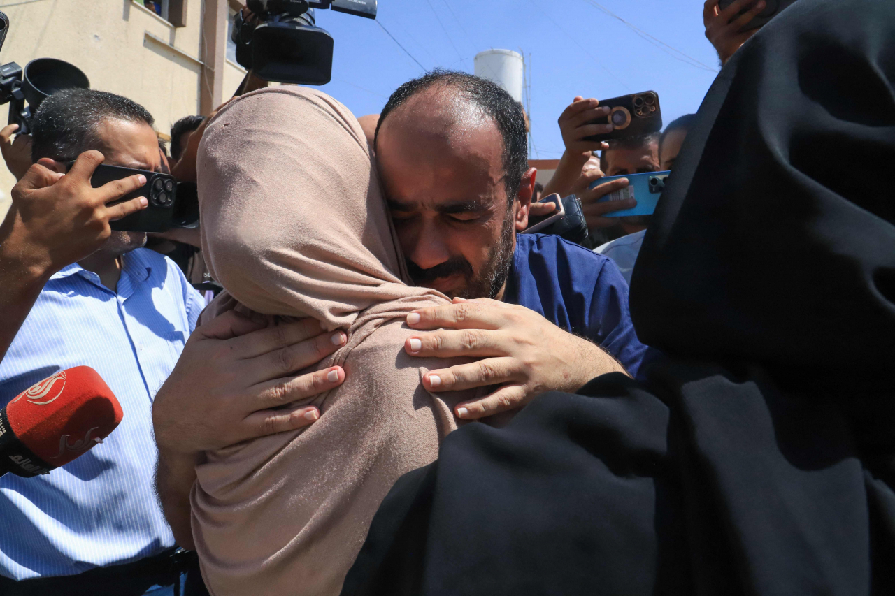 Al-Shifa hospital director Mohammed Abu Salmiya who was detained by Israeli forces since November, is welcomed by relatives after his release alongside other detainees, at Nasser hopsital in Khan Yunis in the southern Gaza Strip, Monday, amid the ongoing conflict between Israel and the Palestinian Hamas militant group. (AFP-Yonhap)