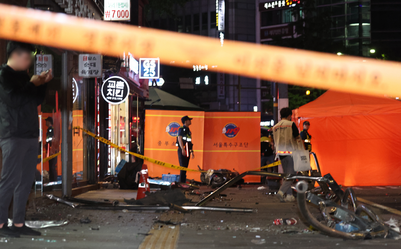Debris is strewn on the sidewalk of an intersection near Seoul City Hall Station in Seoul, South Korea, where a major car accident occurred on Monday night. (Yonhap)