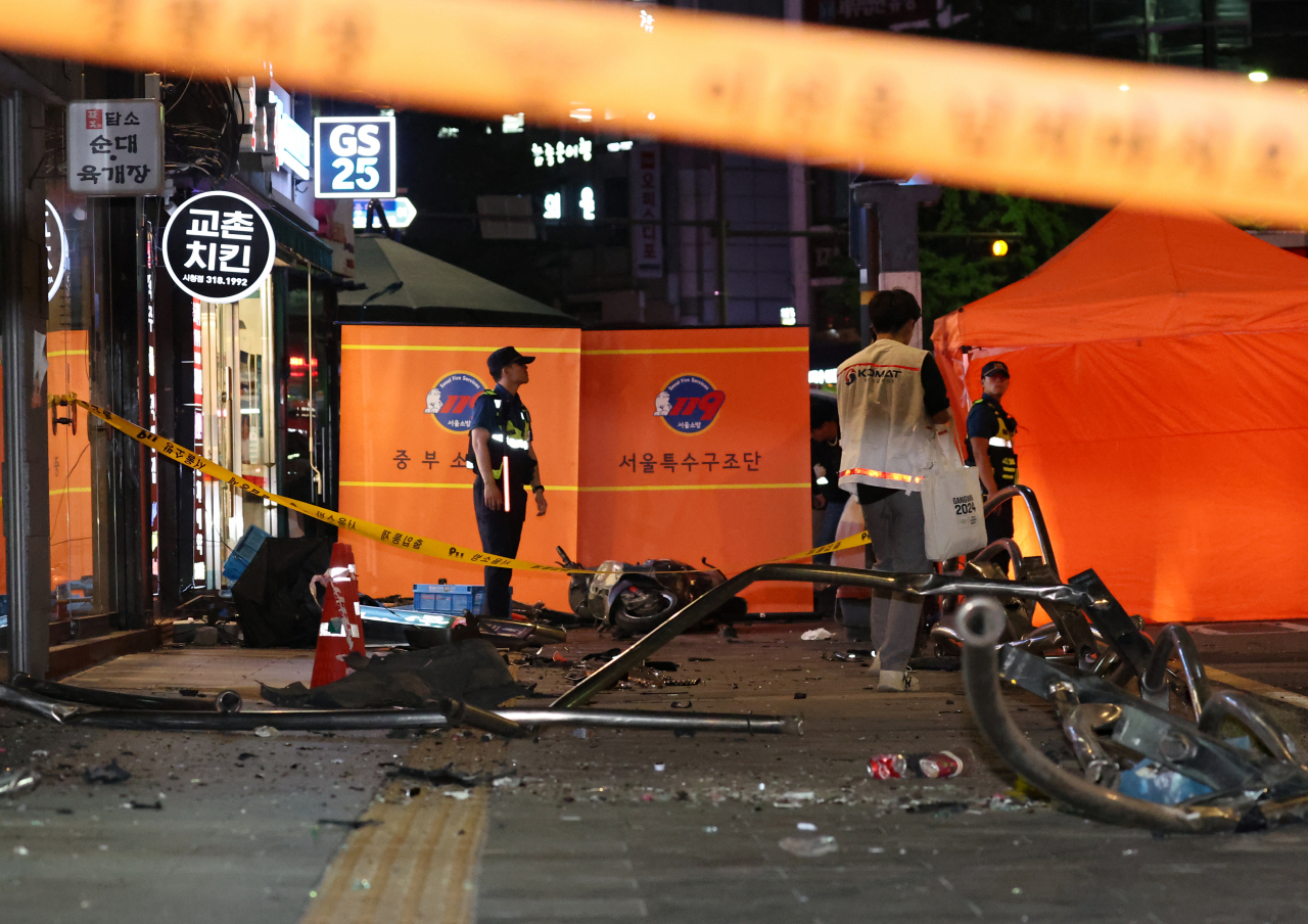 Police officials are stationed near Exit No. 7 of City Hall Station on Monday following a deadly car crash involving nine casualties near the area. (Yonhap)