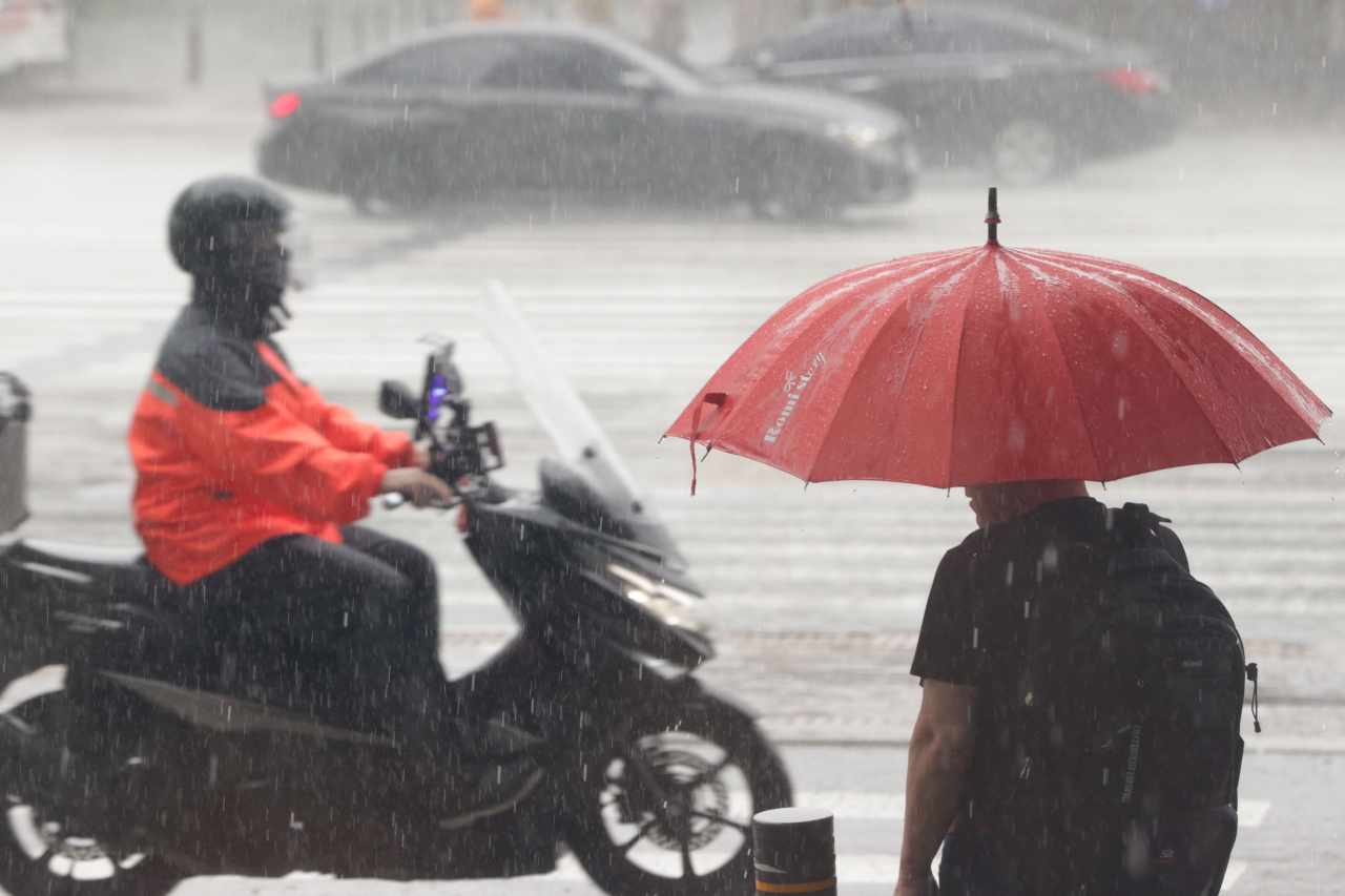 A delivery worker in the rain at Yeouido, western Seoul on Tuesday (Yonhap)