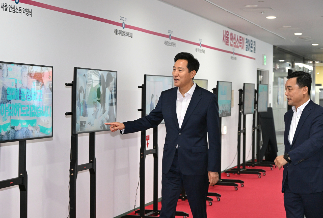 Seoul Mayor Oh Se-hoon tours a gallery showcasing the progress of the Seoul Safety Income initiative before attending the 