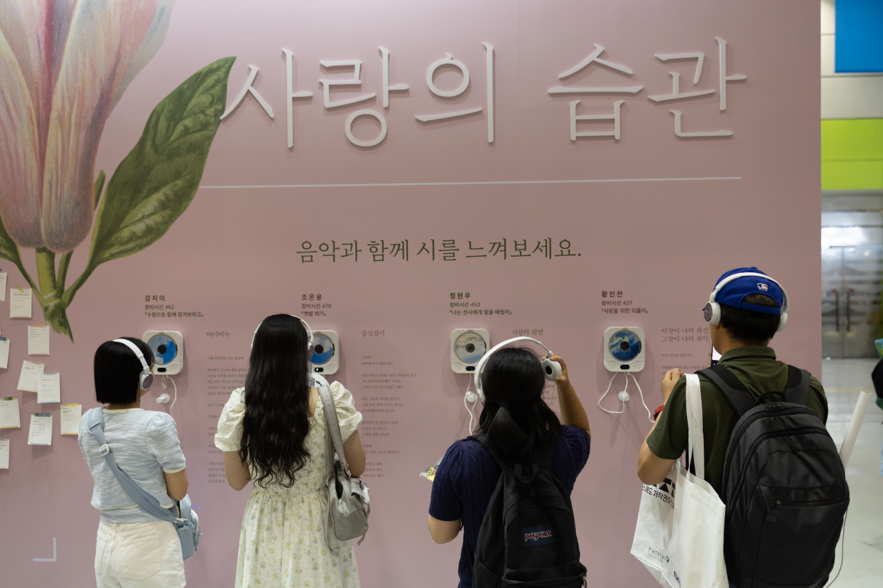 Visitors listen to music matched with poems at the Changbi Publisher booth at the Seoul International Book Fair at Coex in southern Seoul, June 26. (Yonhap)