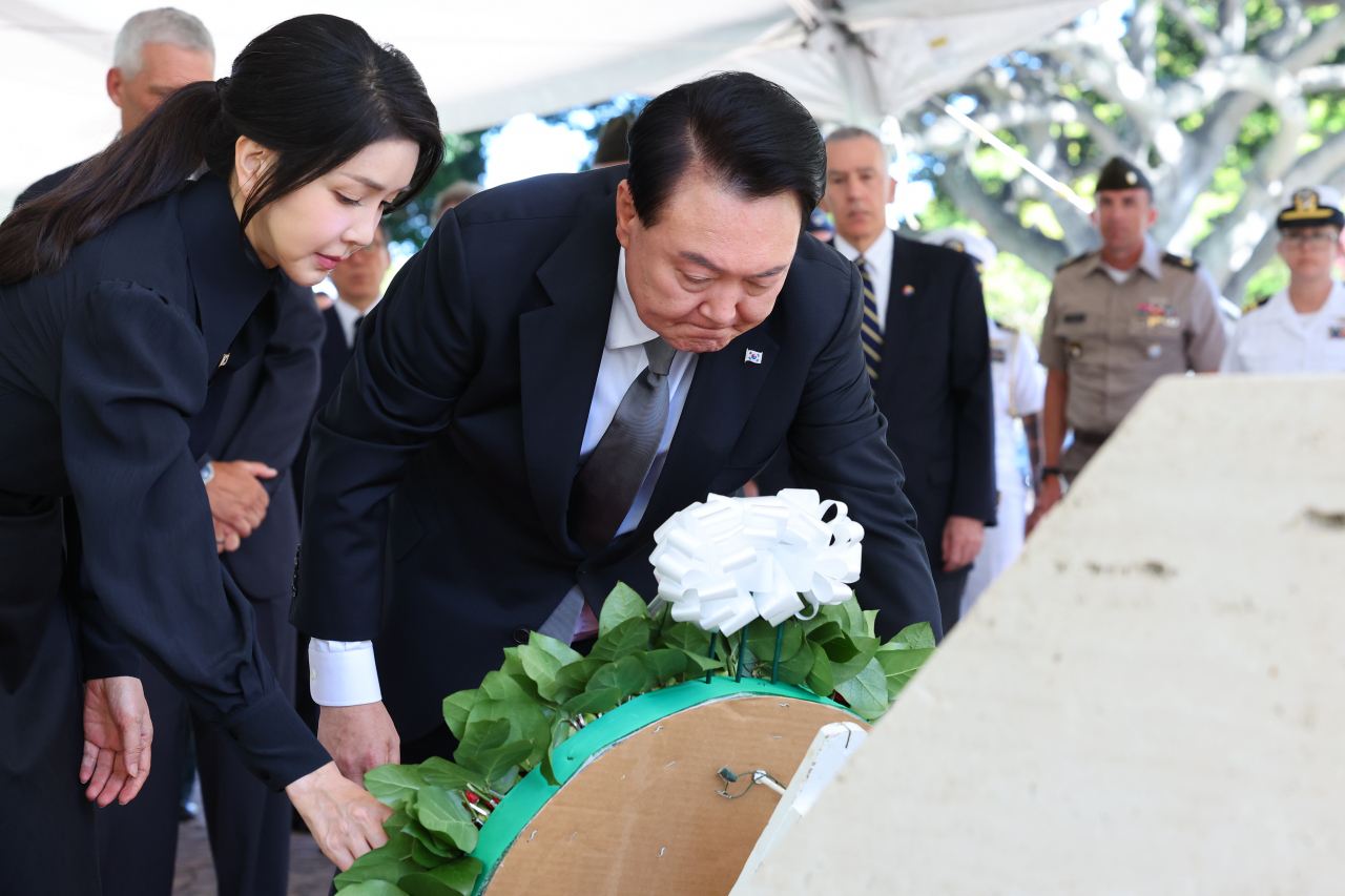 President Yoon Suk Yeol (second from left, front) and first lady Kim Keon Hee (left, front) lay a wreath of flowers Monday at the National Memorial Cemetery of the Pacific, where some 10,000 bodies of soldiers who took part in the 1950-53 Korean War and their bereaved families are laid to rest. (Yonhap)