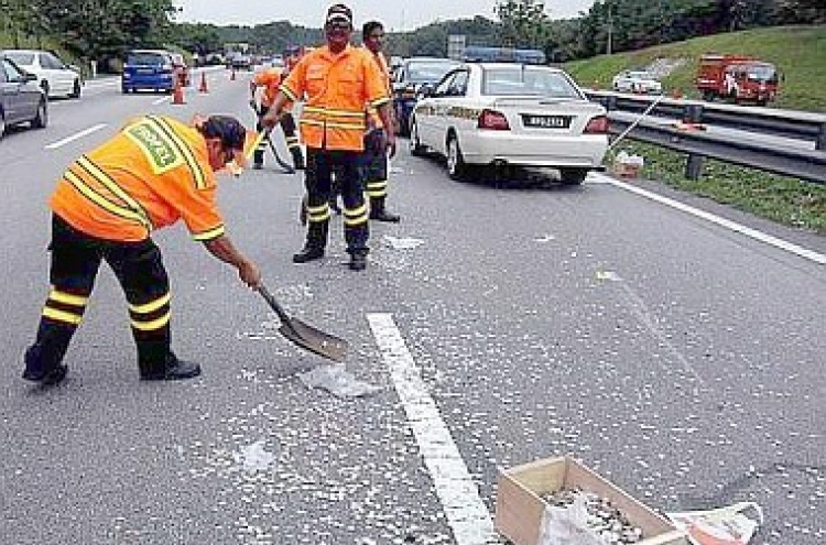 Motorists risk lives to collect coins strewn on highway