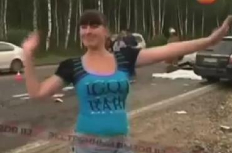 Shameful car passenger dances next to dead bodies