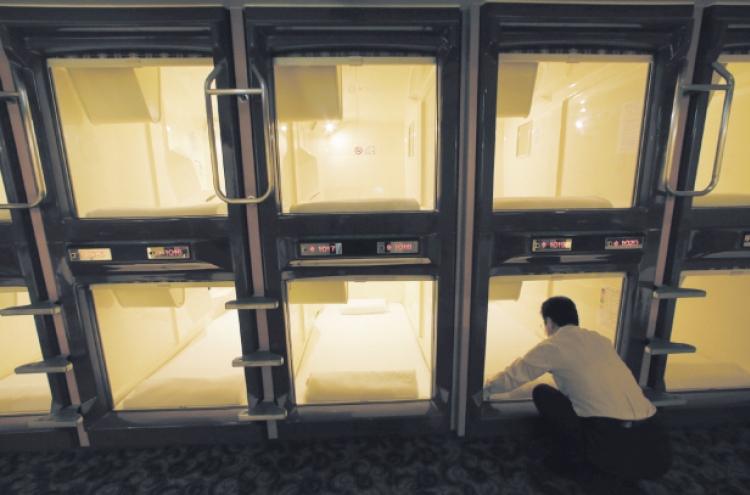 Squeezing into capsule hotel room in Japan