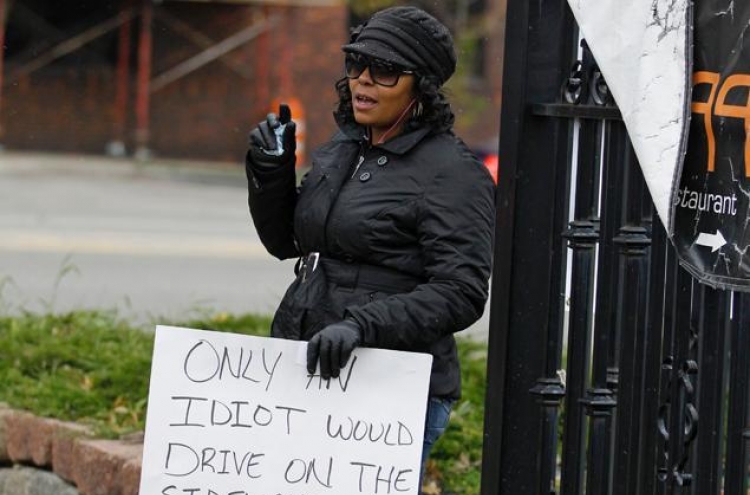 U.S. woman who drove on sidewalk holds ‘idiot’ sign