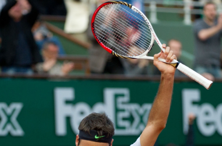 Federer rallies to beat Simon