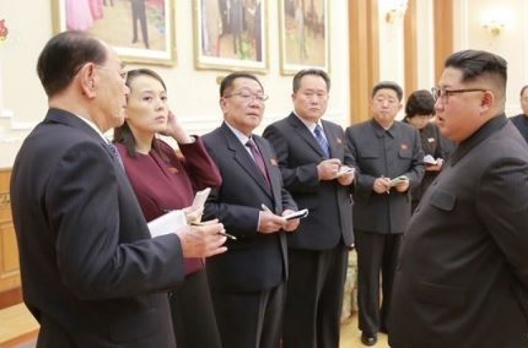 Who are nine NK officials accompanying Kim Jong-un?
