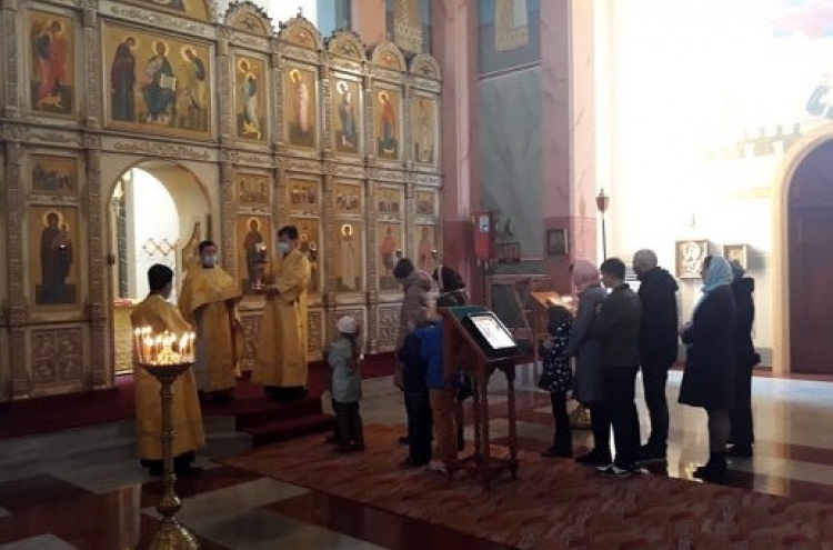 Worshippers, priests wear masks during Mass service in Pyongyang