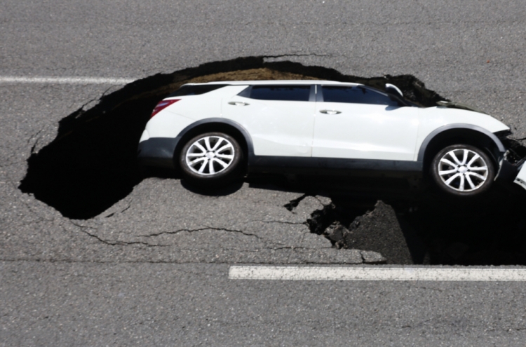 Sinkhole swallows up car, injuring 2 in Seoul