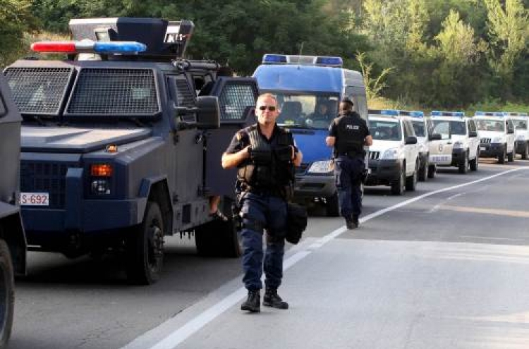 Kosovo police units wait near blockades set up by Kosovo Serbs on the Leposavic-Mitrovica road on Tuesday. AFP-Yonhap News