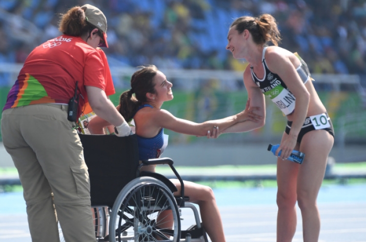 [Newsmaker] Runners help each other after fall, lifting Olympic spirit