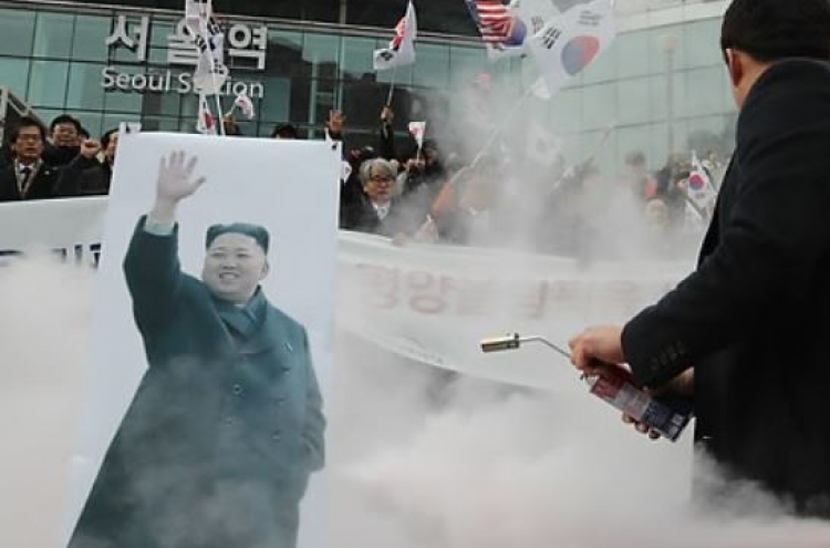 Protesters burn picture of NK leader in rally against Olympic participation