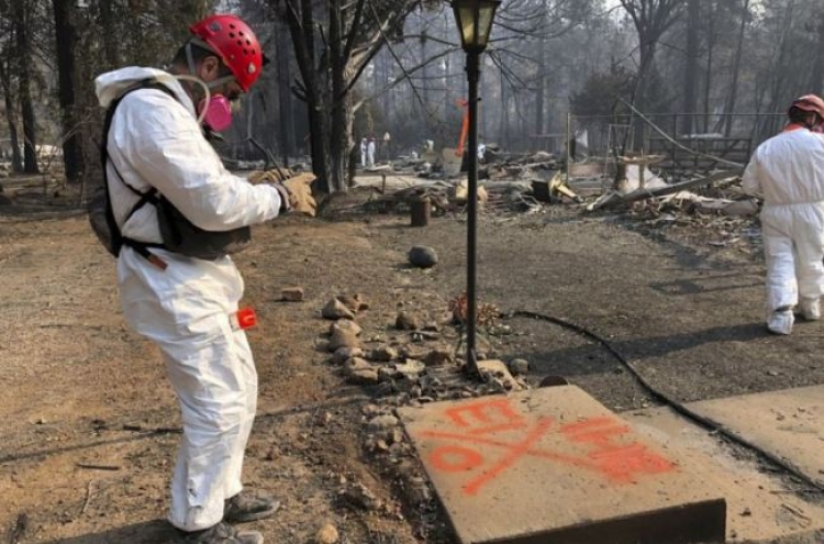 Searchers in California wildfire step up efforts before rain