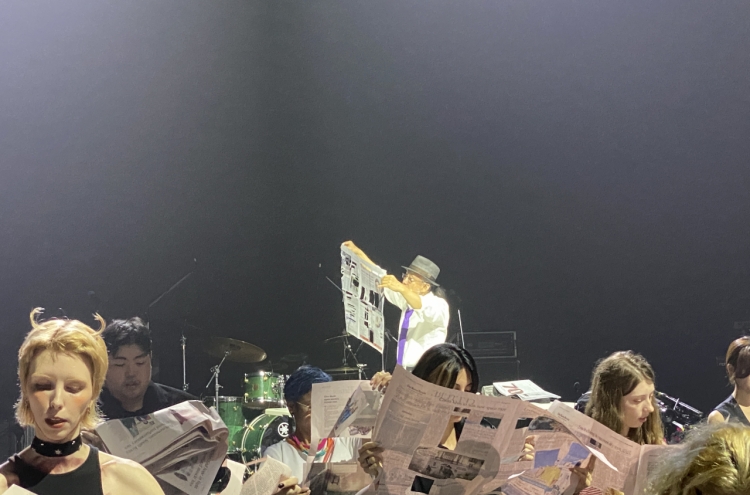 Art performance invites 100 participants to read newspapers on stage